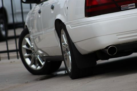 2000 Mercury Grand Marquis - The rear of a white sedan is shown, a chrome exhaust tip and a SuperMotors watermark.