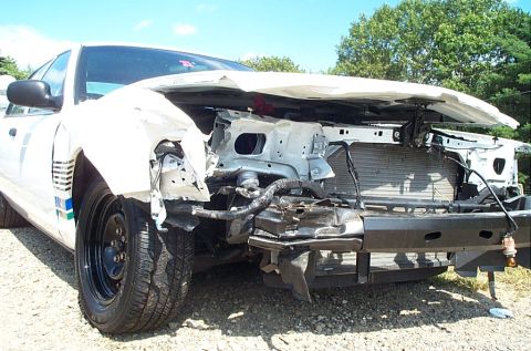 2001 Ford Crown Victoria - The front end of a white 2001 Ford Crown Victoria sustained significant damage, revealing the radiator and internal components.