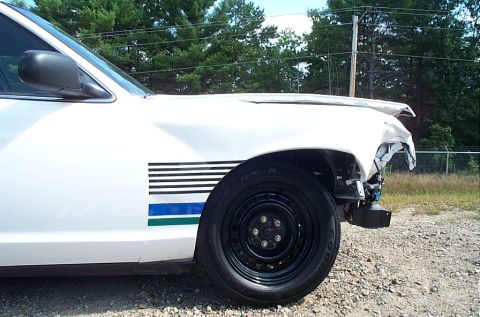 2001 Ford Crown Victoria - Front side view of a damaged 2001 Ford Crown Victoria showing a dented fender and hood.
