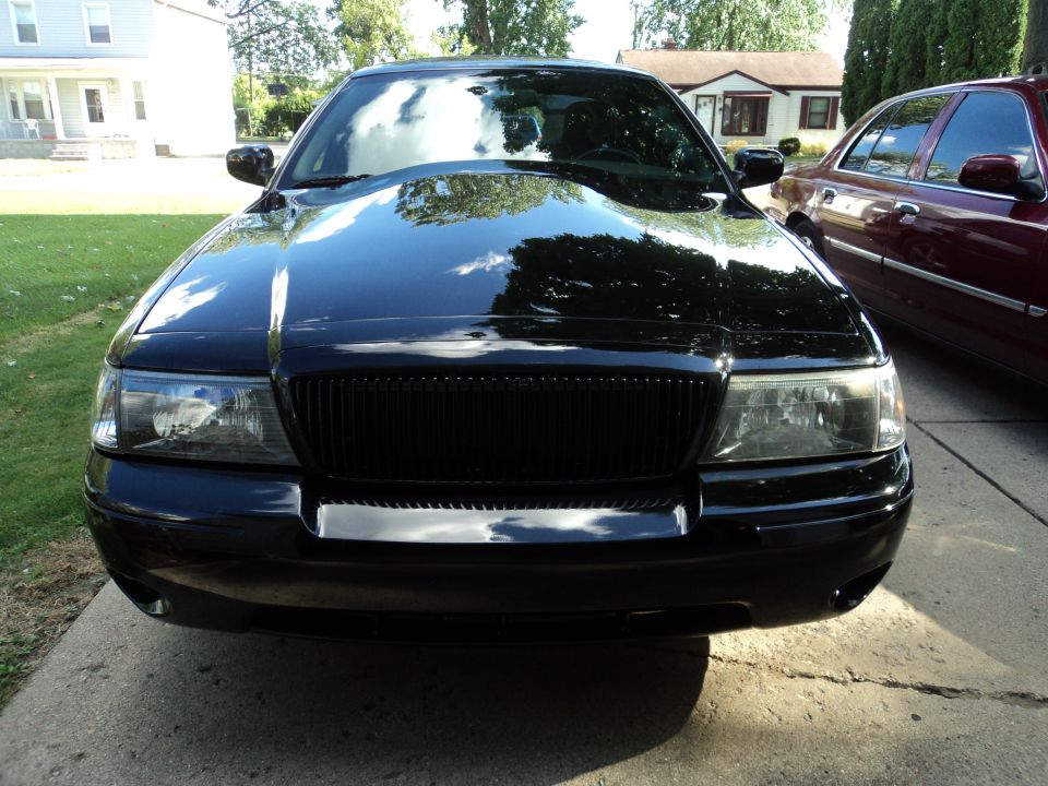 Front view of a black Mercury Grand Marquis parked on a driveway.