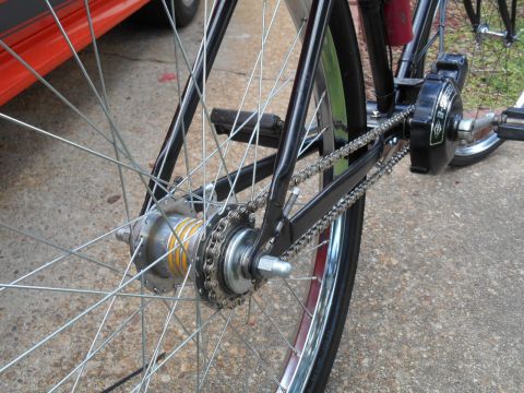 Close-up of a bicycle's rear wheel, chain, gears, and three-speed hub.