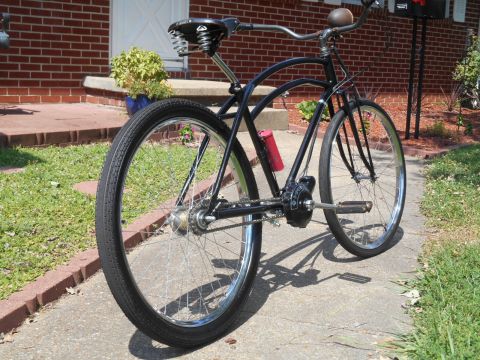Black cruiser bicycle with red water bottle.