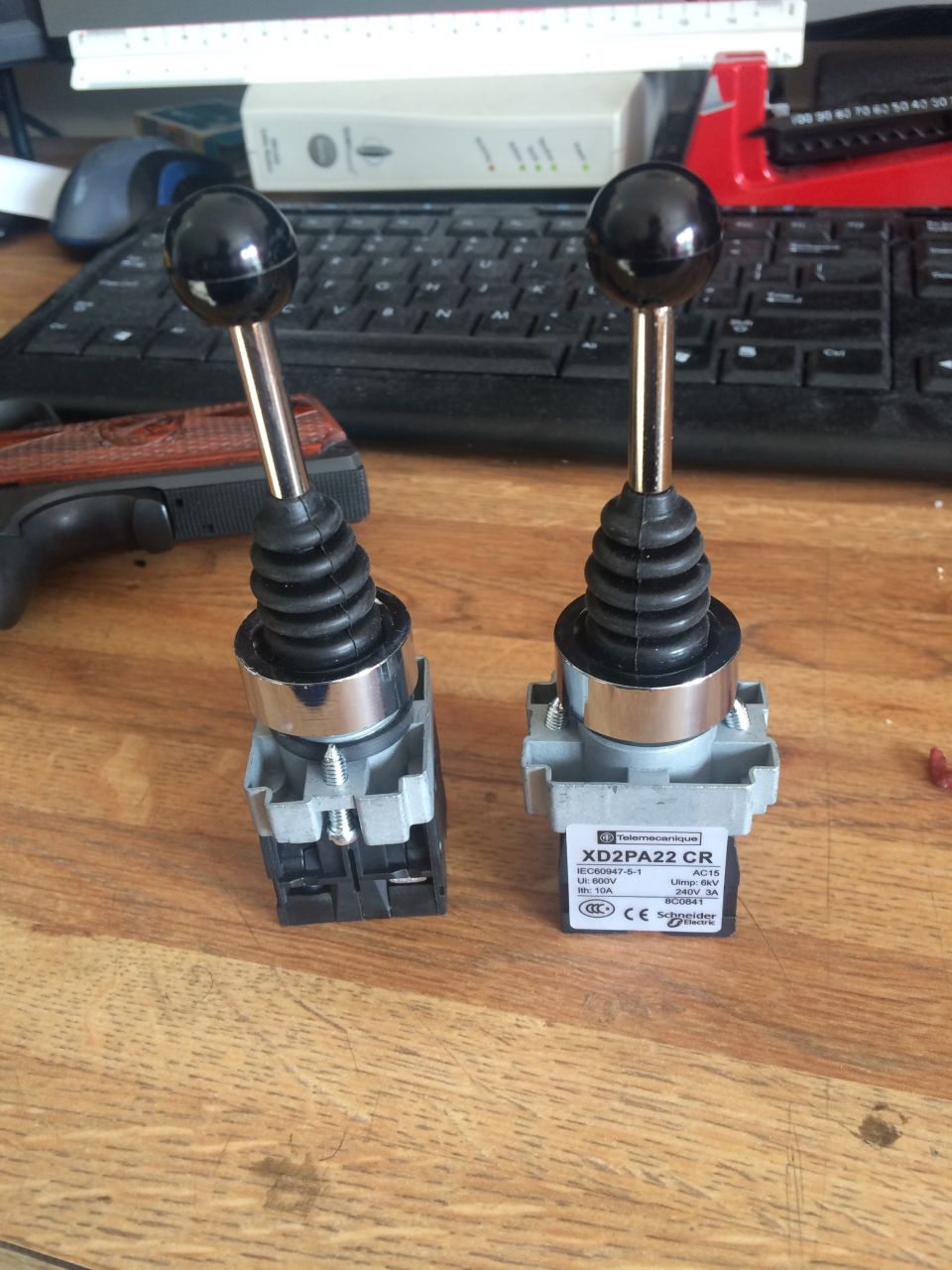 Two industrial joysticks with black ball grips