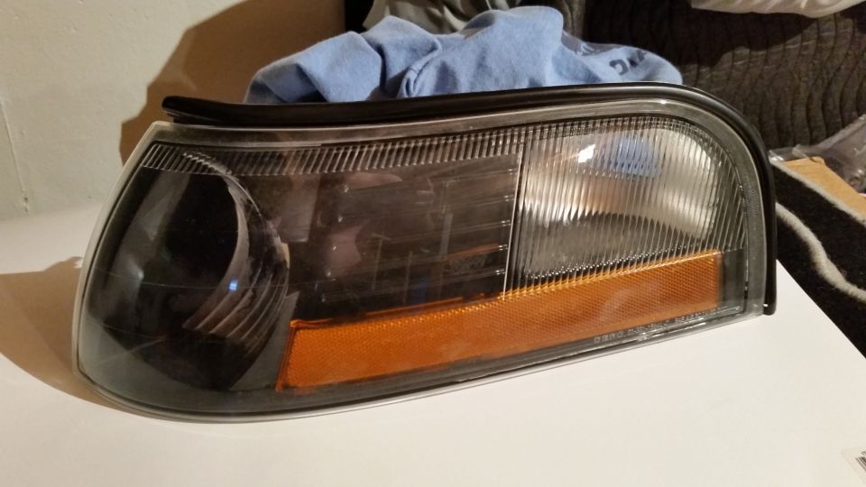 Aftermarket headlight assembly with clear lens and black housing.