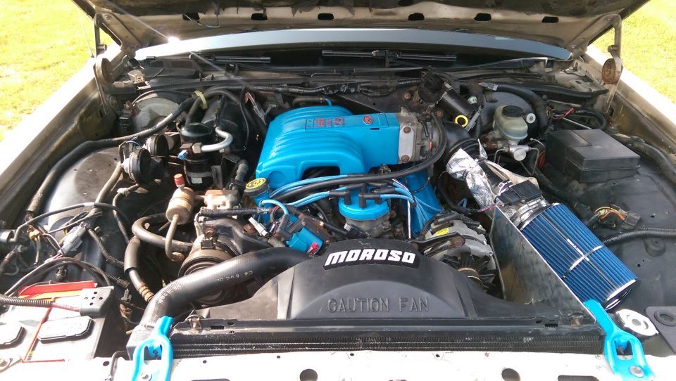 1990 Ford Crown Victoria engine bay with blue intake manifold and air filter.