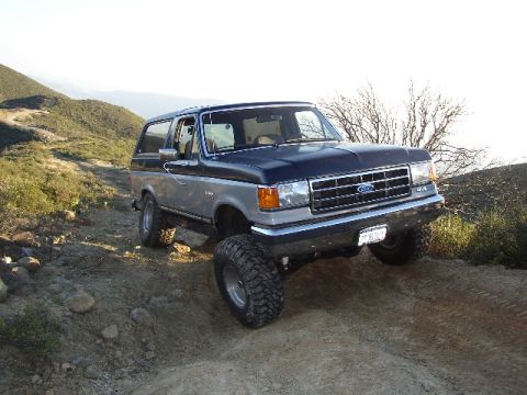1989 Ford Bronco - This lifted Ford Bronco navigates a dirt path, its off-road capabilities.