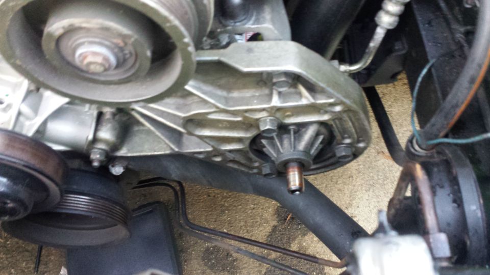 Close-up of car engine water pump and pulleys.