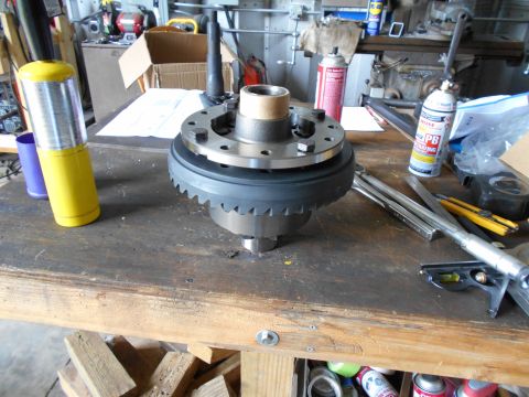1992 Ford Bronco - A differential part is shown on a wooden workbench with various tools and spray cans. The part appears to be a differential carrier with a…