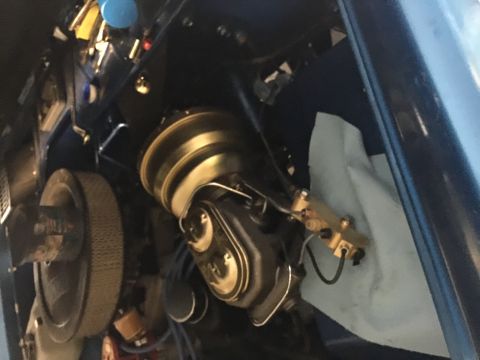 1974 Ford Bronco - This is a close-up view of a vehicle's engine bay, focusing on the brake booster and master cylinder assembly. The components are primarily…