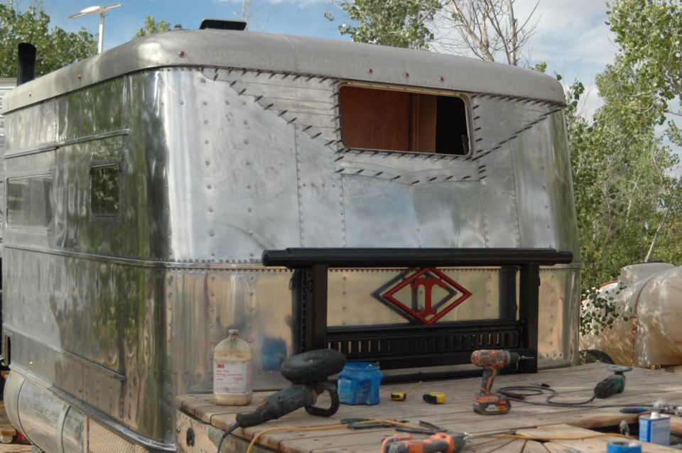 Polished aluminum Airstream-style trailer rear with tools on deck