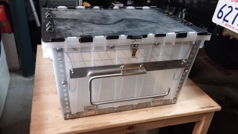 1985 Toyota 4Runner - A clear plastic and metal kitchen chuck box is shown on a wooden surface.