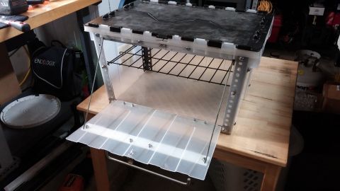 1985 Toyota 4Runner - A clear plastic chuck box with a metal frame and wire racks is shown with its door open.