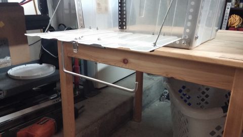 1985 Toyota 4Runner - A metal and plastic kitchen chuck box is set up on a wooden table, likely in a garage or workshop setting.