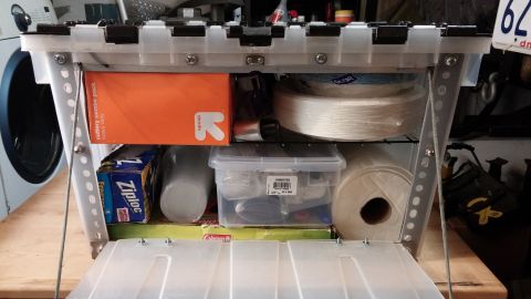 1985 Toyota 4Runner - A clear plastic storage container is open, revealing various household and craft supplies organized within its compartments.