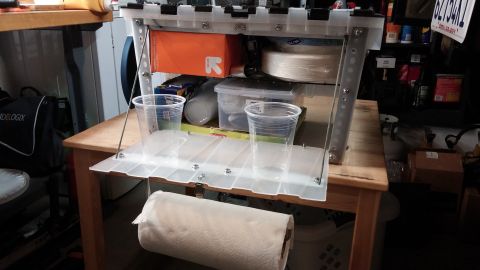 1985 Toyota 4Runner - A portable kitchen chuck box is set up on a wooden table, holding various containers and cups.