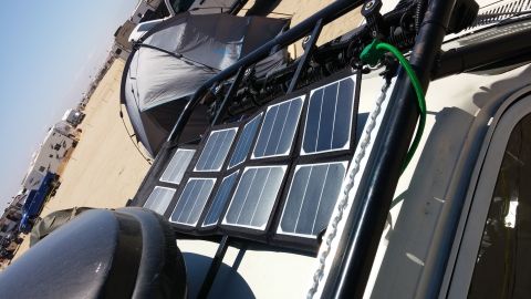 1985 Toyota 4Runner - Vehicle equipped with solar panels and a tent, parked outdoors.