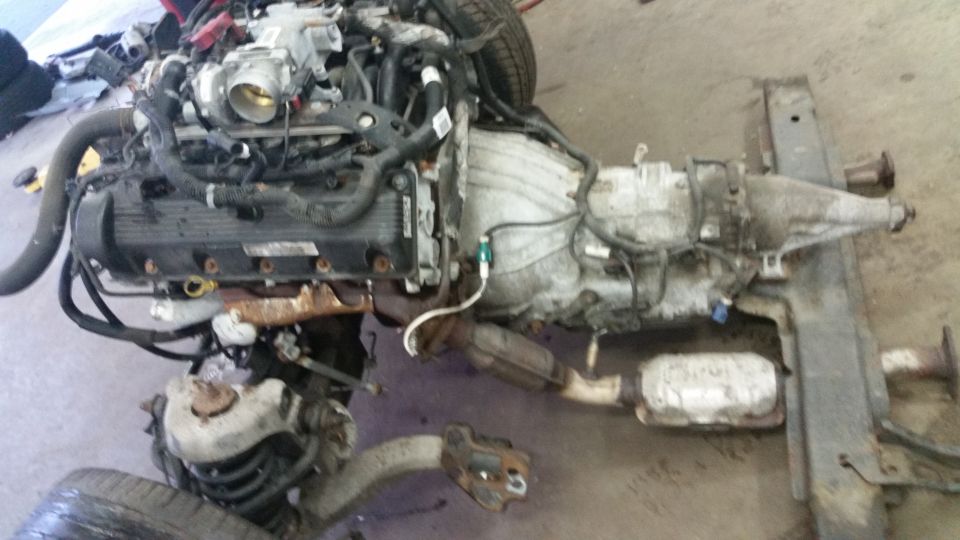 Engine and transmission assembly with exhaust components and frame sections