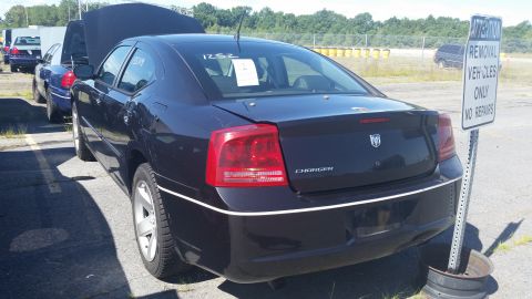2001 Ford Crown Victoria - A dark blue Dodge Charger is parked next to another vehicle, with a sign indicating 'Removal Vehicles Only'.