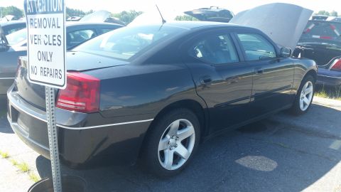 2001 Ford Crown Victoria - Black Dodge Charger sedan in a lot with a sign indicating it's for vehicle removal only.