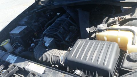 2001 Ford Crown Victoria - The engine bay of a vehicle is shown with its hood open, revealing the engine components.