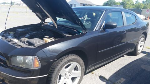 2001 Ford Crown Victoria - Black Dodge Charger with hood open, parked outdoors on a sunny day.