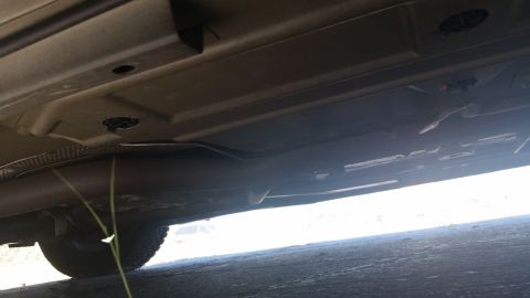 2001 Ford Crown Victoria - A low-angle view of a vehicle's undercarriage, revealing the exhaust system and suspension parts.