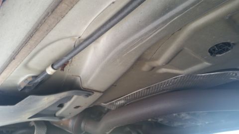 2001 Ford Crown Victoria - Undercarriage view of a vehicle, focusing on the exhaust system and structural elements.