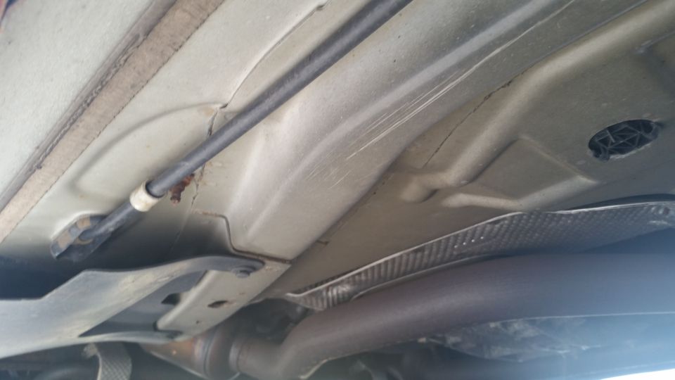 Underside view of a vehicle showing the exhaust pipe, frame, and underbody components
