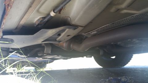 2001 Ford Crown Victoria - A view of the undercarriage of a vehicle, focusing on the exhaust pipe and structural components.