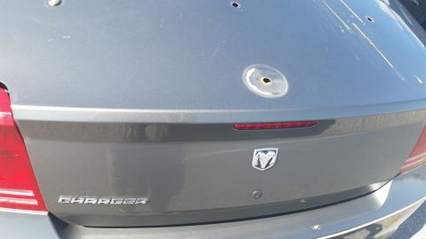 2001 Ford Crown Victoria - Dodge Charger rear with multiple bullet impacts on the trunk lid.