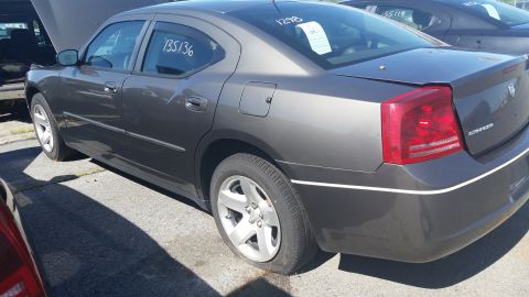 2001 Ford Crown Victoria - A dark gray sedan sits in a lot with its hood open and a flat rear tire.