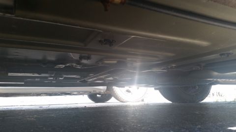 2001 Ford Crown Victoria - A low-angle shot reveals the undercarriage of a vehicle, including its wheels and suspension components.