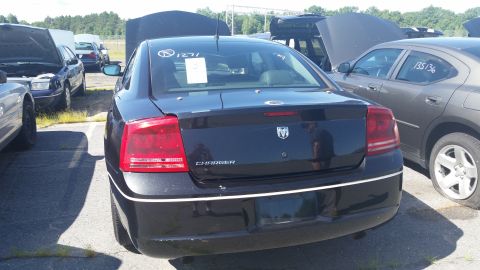 2001 Ford Crown Victoria - Rear view of a black Dodge Charger, identified by its badging and taillights.