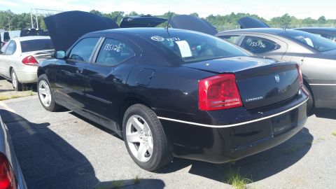2001 Ford Crown Victoria - Rear view of a black Dodge Charger with its hood open, parked outdoors with other vehicles.