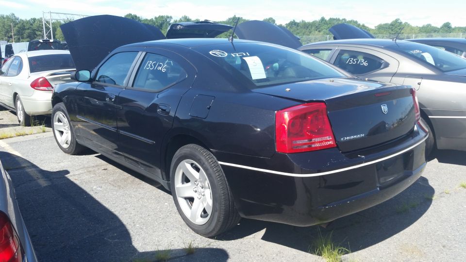 Black Dodge Charger parked in a lot, hood up. White numbers '135126' on driver's side window