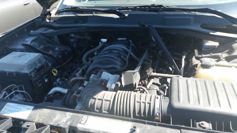 2001 Ford Crown Victoria - The engine bay of a car is visible with the hood raised.