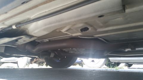 2001 Ford Crown Victoria - The underside of a vehicle, showing the exhaust pipe and chassis components, is captured from a low angle.