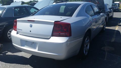 2001 Ford Crown Victoria - Rear view of a silver Dodge Charger with visible text and a dent on the trunk lid.