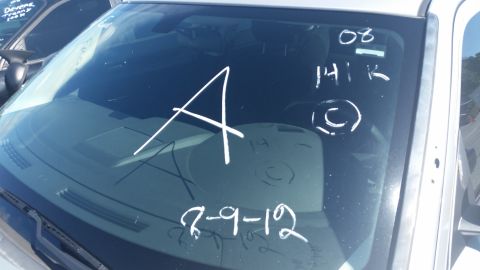 2001 Ford Crown Victoria - Chalk markings on a car's windshield include a large 'A', mileage, and a date.