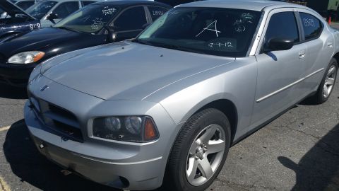 2001 Ford Crown Victoria - A silver sedan is parked in a lot with other vehicles, showing its front and side profile.