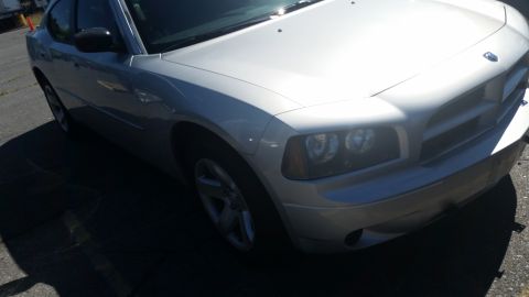 2001 Ford Crown Victoria - Silver Dodge Charger from the front quarter angle, showing its distinctive grille and headlights.