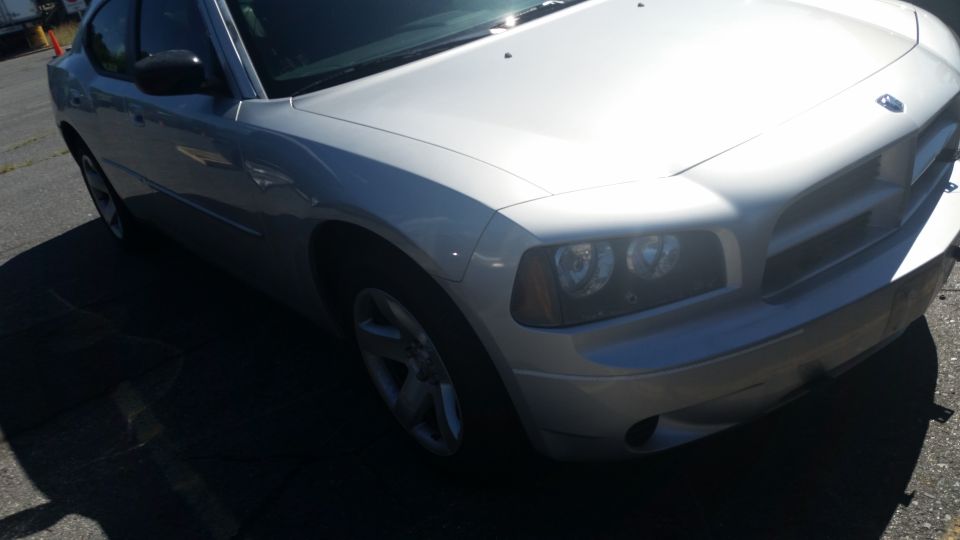 Silver Dodge Charger front quarter view. Headlights and grille visible