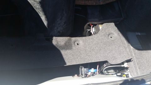 2001 Ford Crown Victoria - The interior of a car's trunk shows carpeting and electrical components.