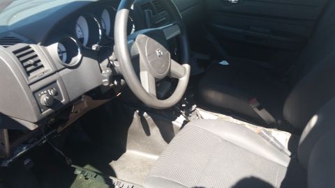2001 Ford Crown Victoria - The interior of a car is shown, a steering wheel with a Dodge emblem and gray fabric seats.