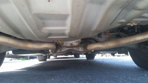 2001 Ford Crown Victoria - Underside view of a car's exhaust system and rear axle, showing dual pipes.