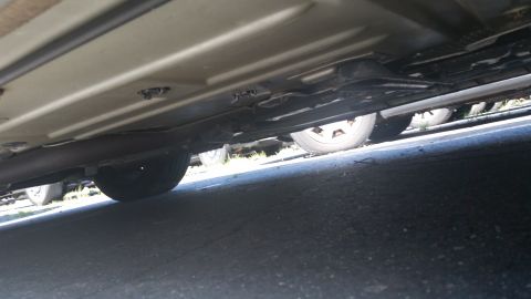 2001 Ford Crown Victoria - The undercarriage of a vehicle is shown, with another vehicle partially visible in the background.