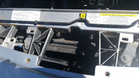 2001 Ford Crown Victoria - Front view of a vehicle's radiator support and cooling fins, with warning labels attached.