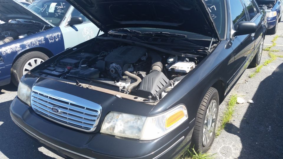 Black 2001 Ford Crown Victoria front quarter view with hood open showing engine