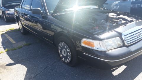 2001 Ford Crown Victoria - Front view of a 2001 Ford Crown Victoria with its hood open, parked outdoors.