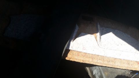 2001 Ford Crown Victoria - The interior of a car trunk shows exposed insulation and structural components after the lining was removed.